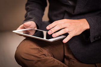 Close-up of man using tablet computer while sitting