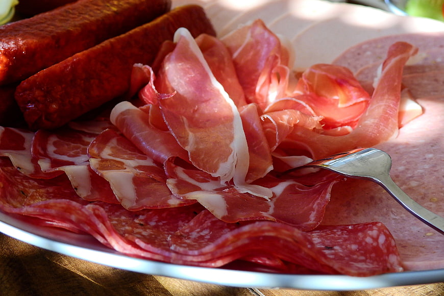 Assorted cured meats and salami on a white plate