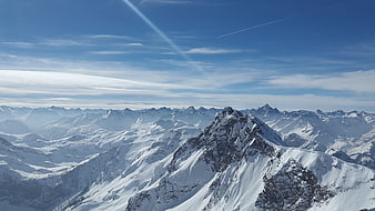 Snow-Covered Mountain Peaks Under Blue Sky