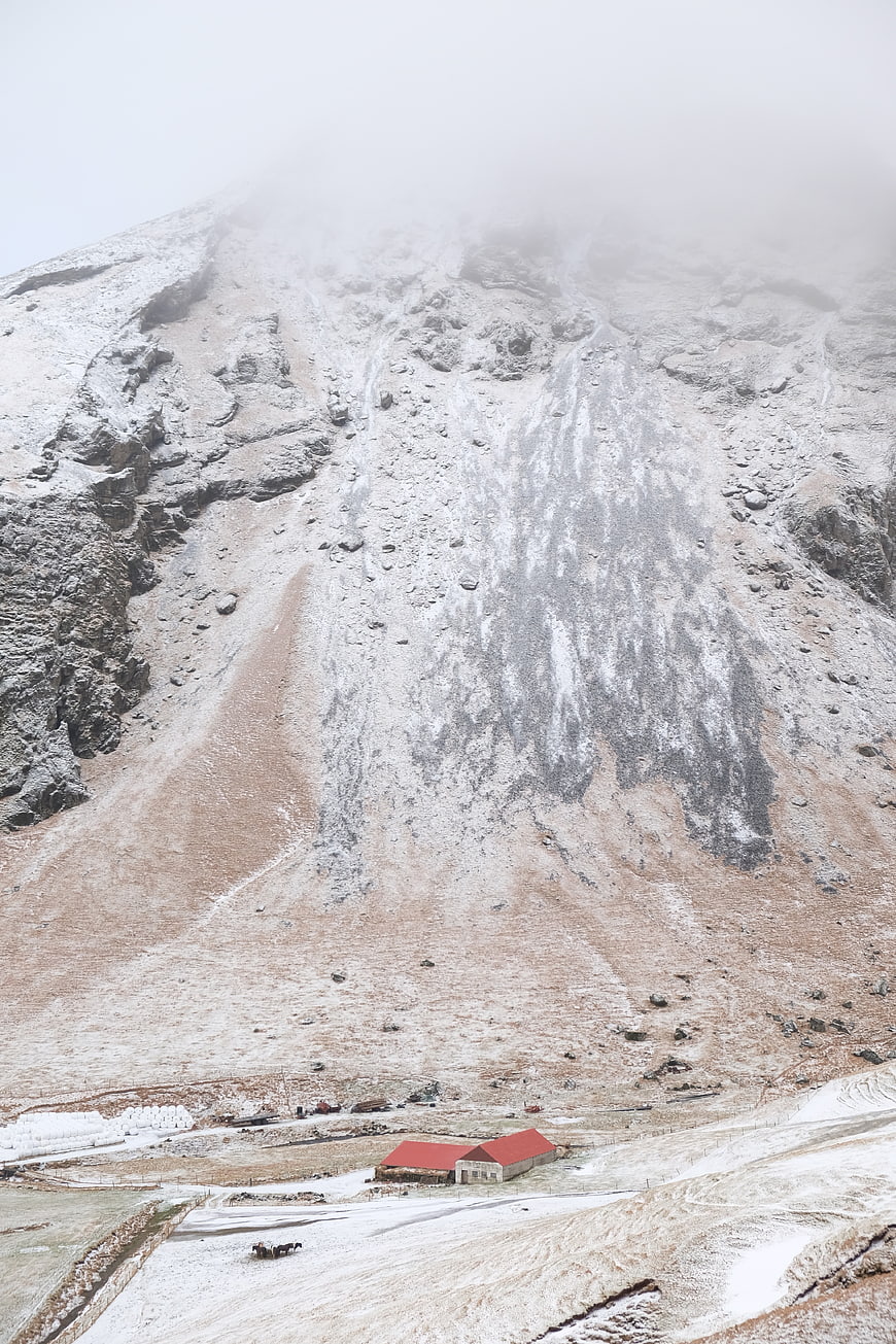 Snowy Mountain Landscape with Red Barn and Fog