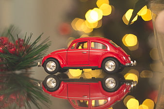 Red Toy Volkswagen Beetle with Christmas Lights and Reflection
