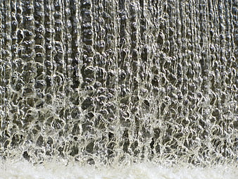 Close-up of cascading water texture with bubbles and foam