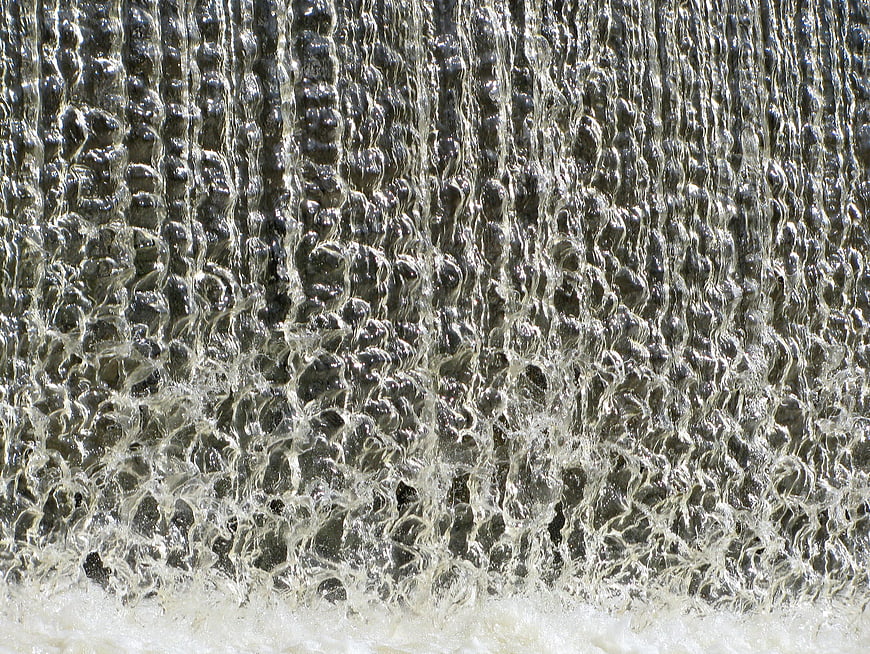 Close-up of cascading water texture with bubbles and foam