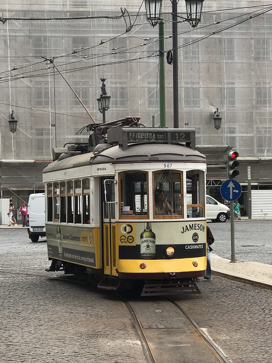 Vintage yellow tram on cobblestone street in Lisbon