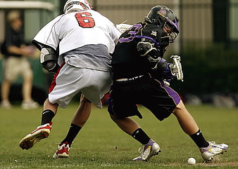 Lacrosse players competing for the ball on a grass field