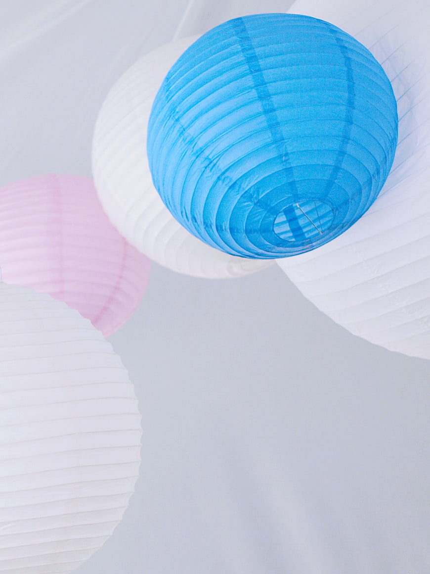 Blue and Pink Paper Lanterns Hanging Against White Background