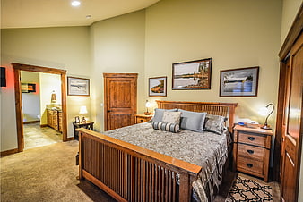Cozy rustic master bedroom with wooden furniture and landscape art