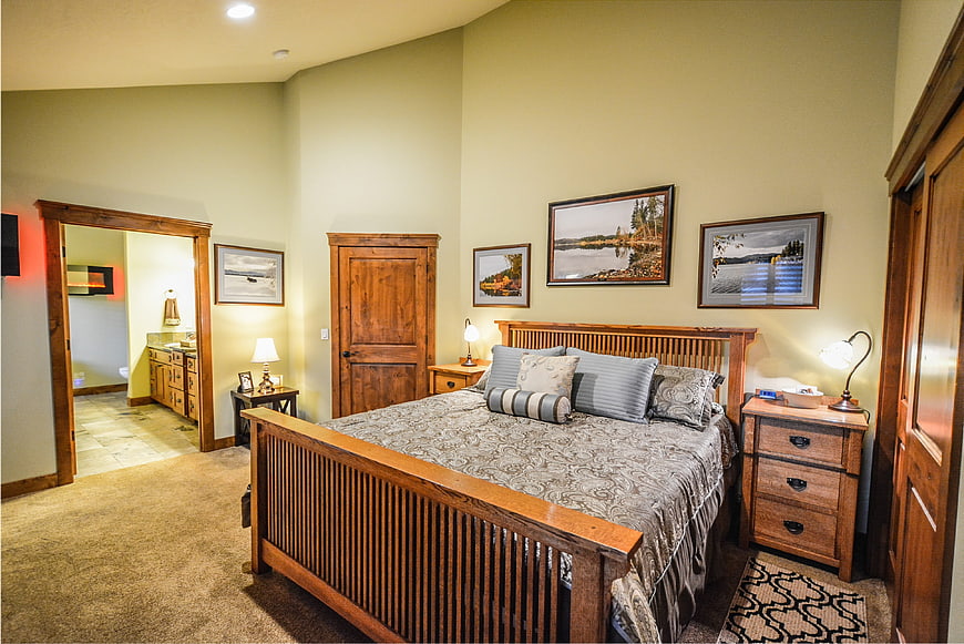 Cozy rustic master bedroom with wooden furniture and landscape art