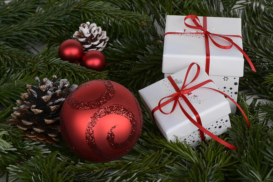 Christmas gifts and red ornaments on fir branches