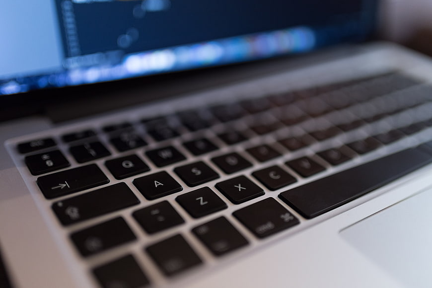 Close-up of laptop keyboard with blurred screen background