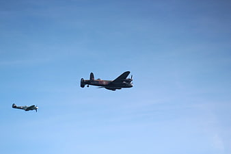 Vintage WWII Bomber and Fighter Plane Flying in Blue Sky