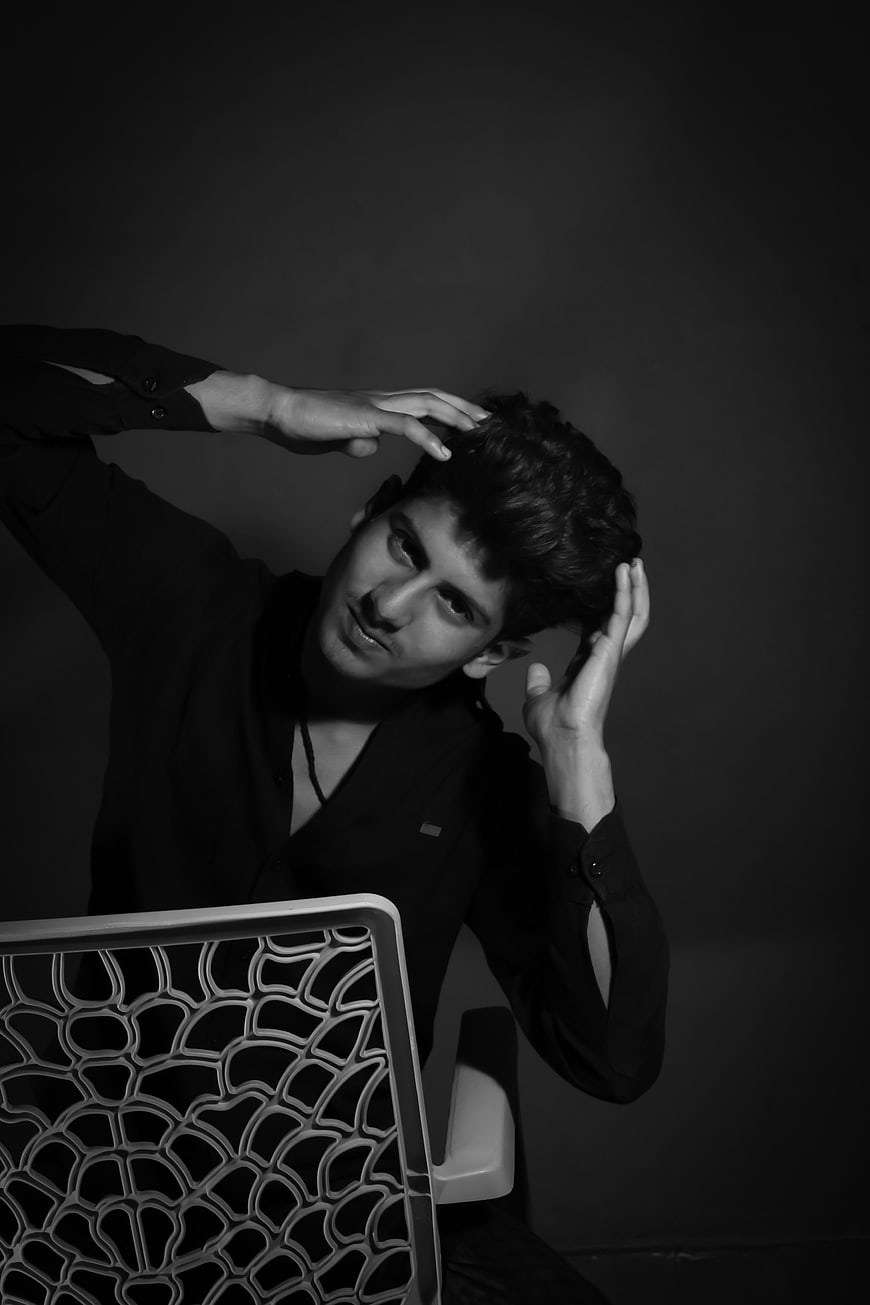 Dramatic black and white portrait of young man in chair