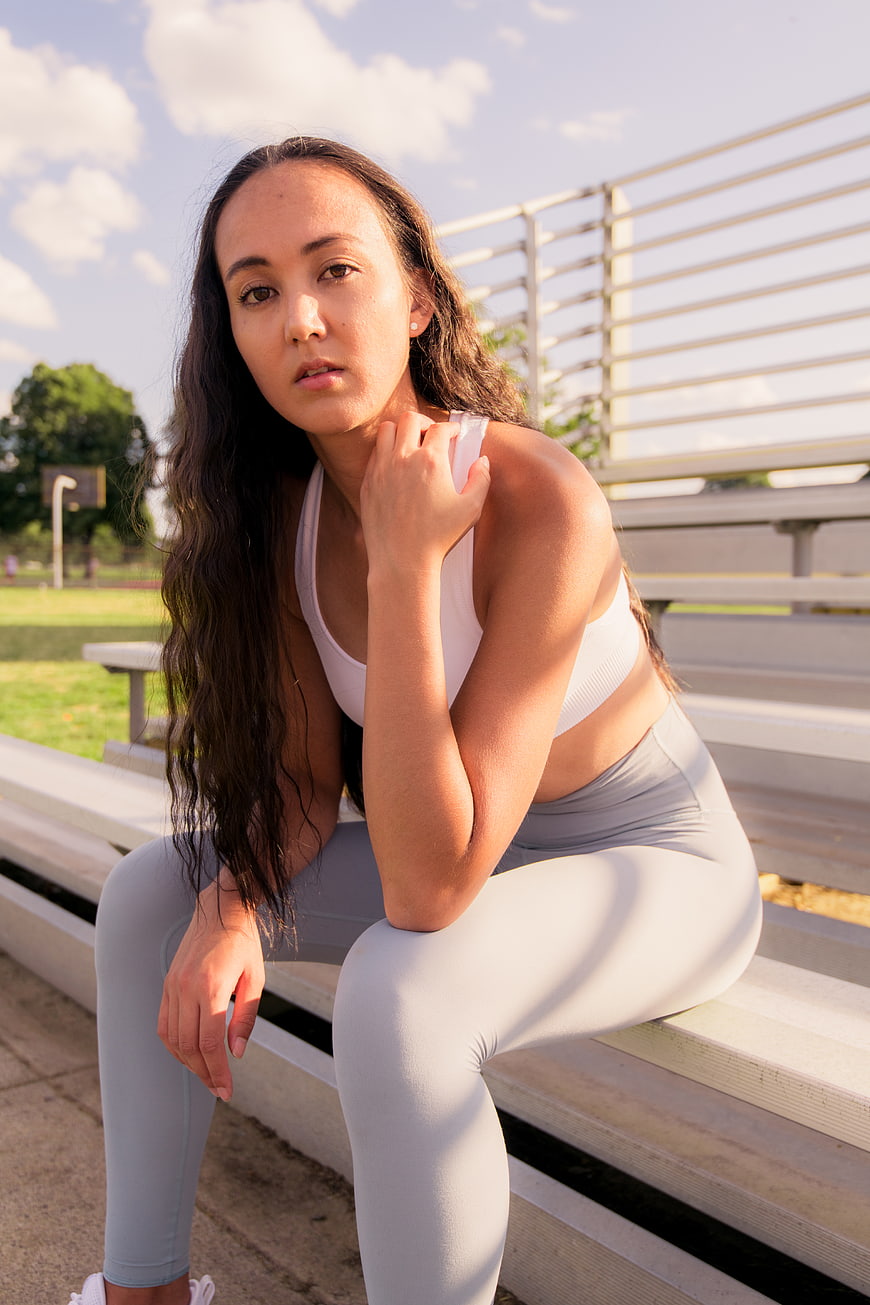 Fit Woman Resting on Outdoor Bleachers in Sportswear