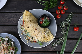 Thai egg net wrap with dipping sauce on rustic wooden table