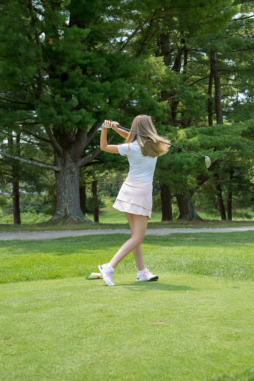 Young Woman Golfing on Green Course