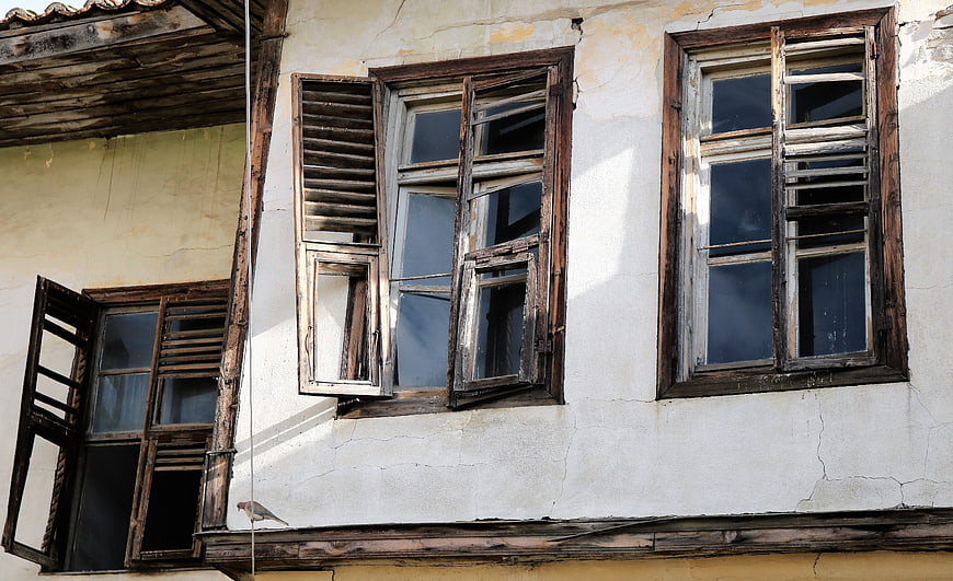 Old wooden windows on a weathered building facade