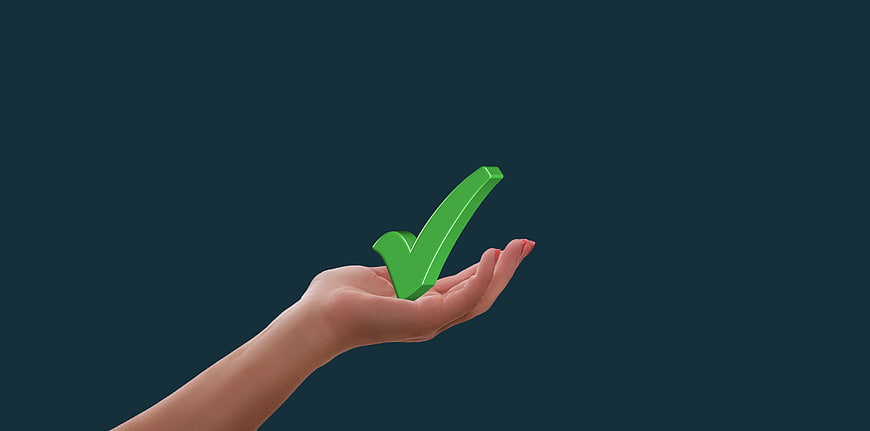 Hand holding 3D green checkmark on dark blue background