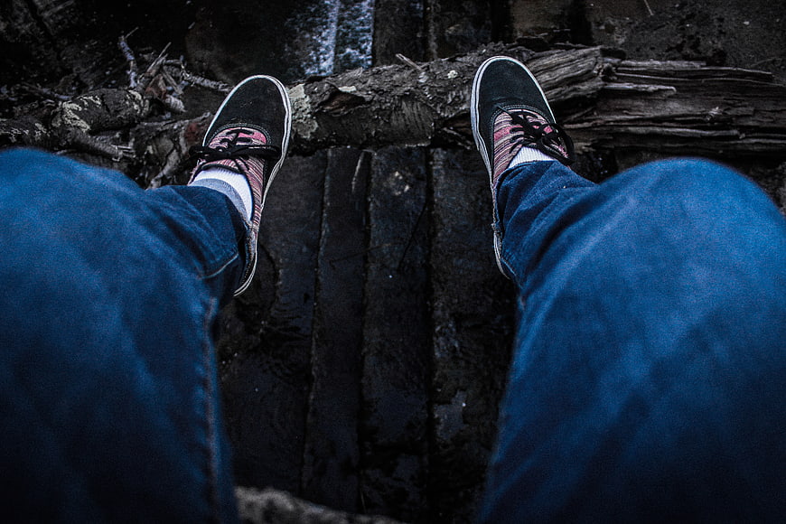 First Person View of Sneakers on Wooden Log