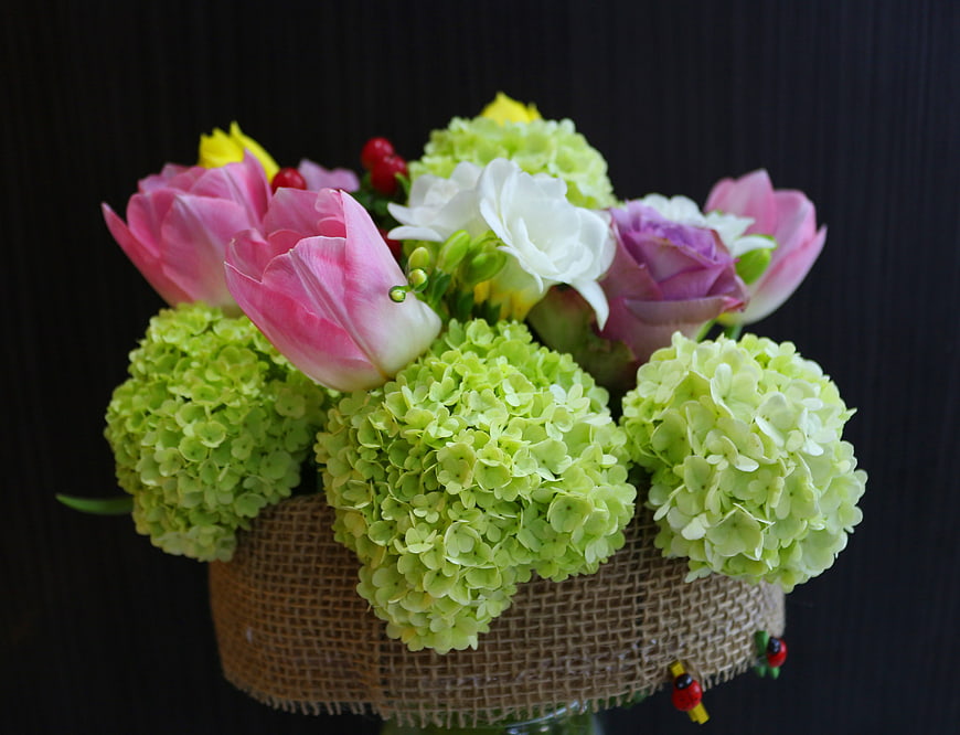 Spring floral arrangement with pink tulips and green hydrangeas