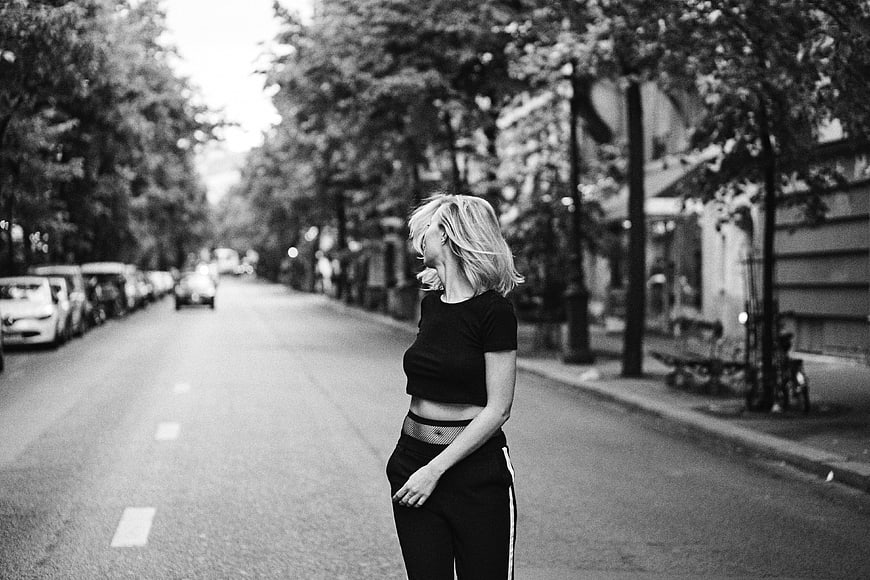 Black and white portrait of woman standing on city street