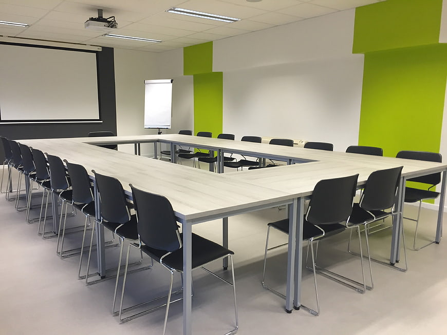 Modern U-shaped conference room with green accents