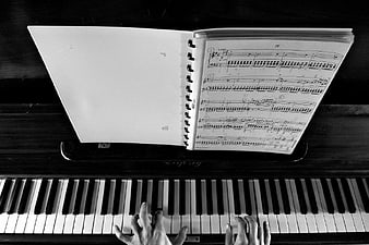 Hands Playing Piano with Sheet Music