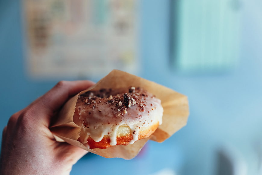 Hand Holding Glazed Doughnut with Sprinkles