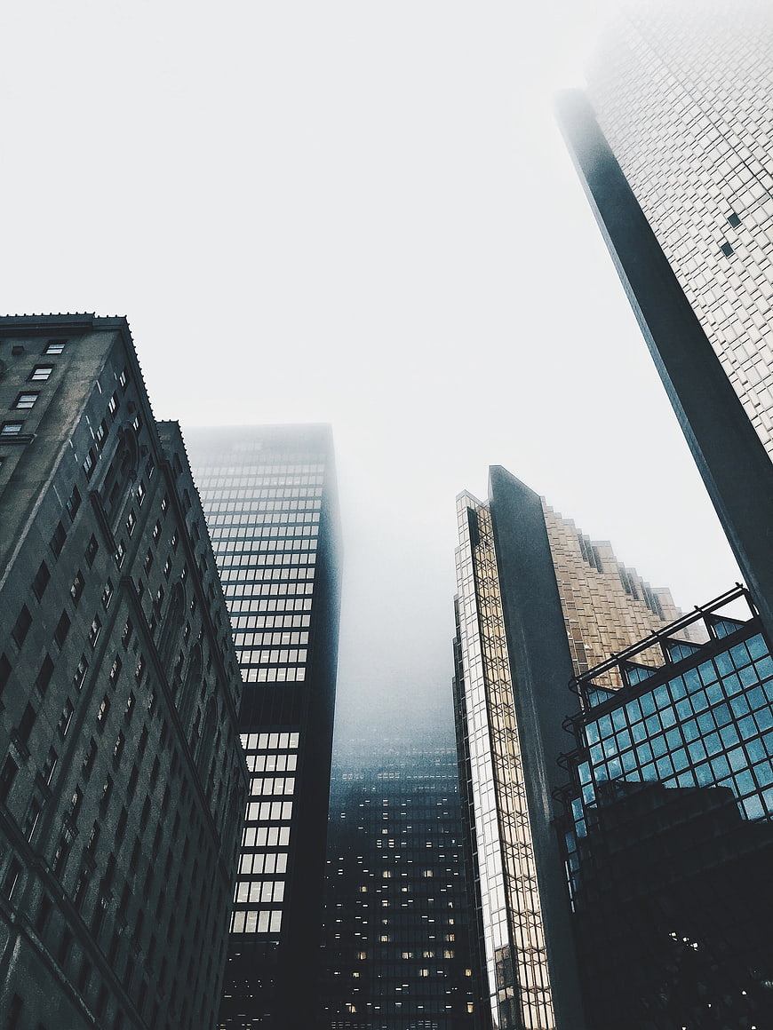 Low angle view of skyscrapers in foggy city