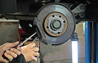 Mechanic repairing car brake disc in auto repair shop