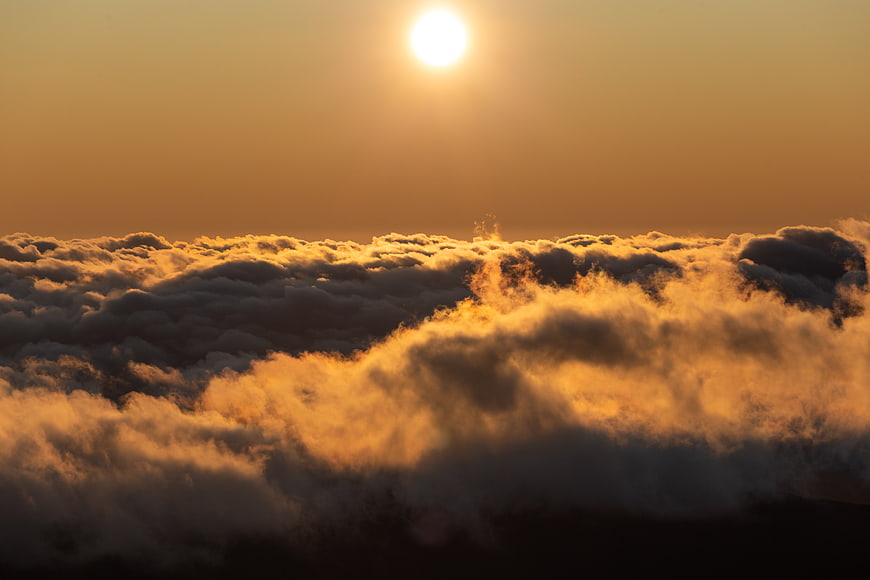 Golden Sun Shining Above Sea of Clouds at Sunset