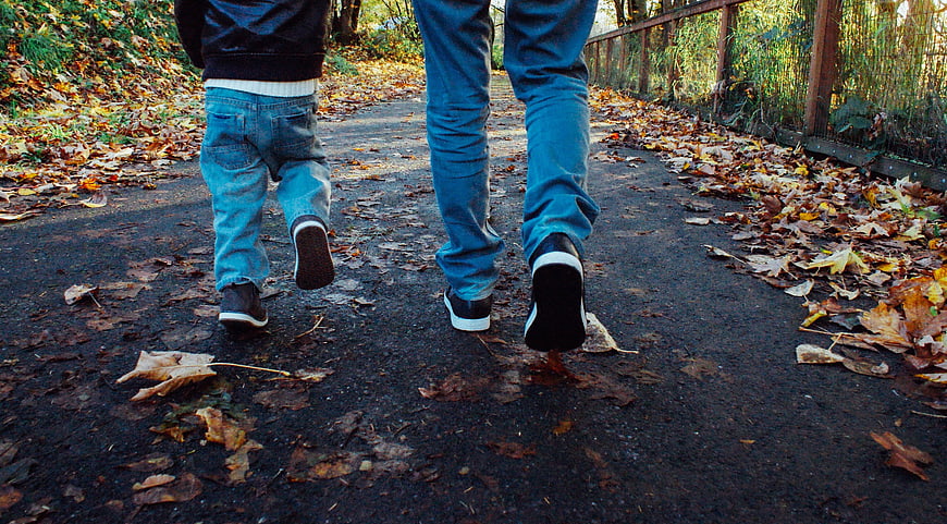 Father and son walking on autumn path