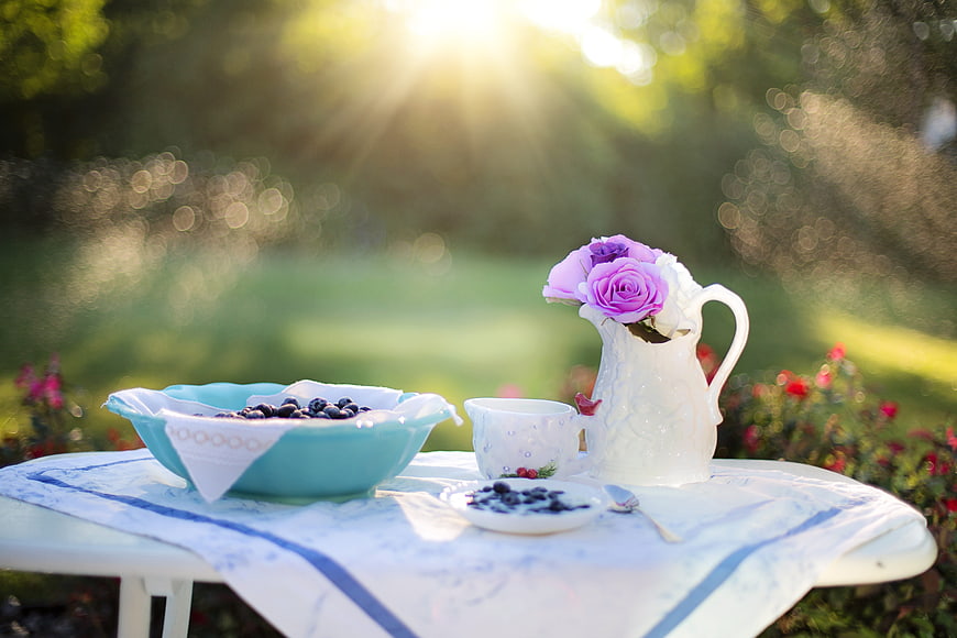 Fresh Blueberries and Tea on Outdoor Table with Sunlight