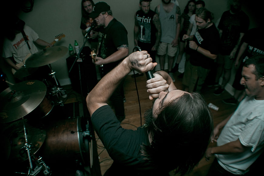 Intense male singer performing live rock concert with band