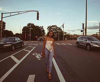 Woman Walking Down Urban Street at Sunset