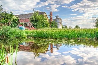 Rustic Farmhouse with Silo Reflected in Pond