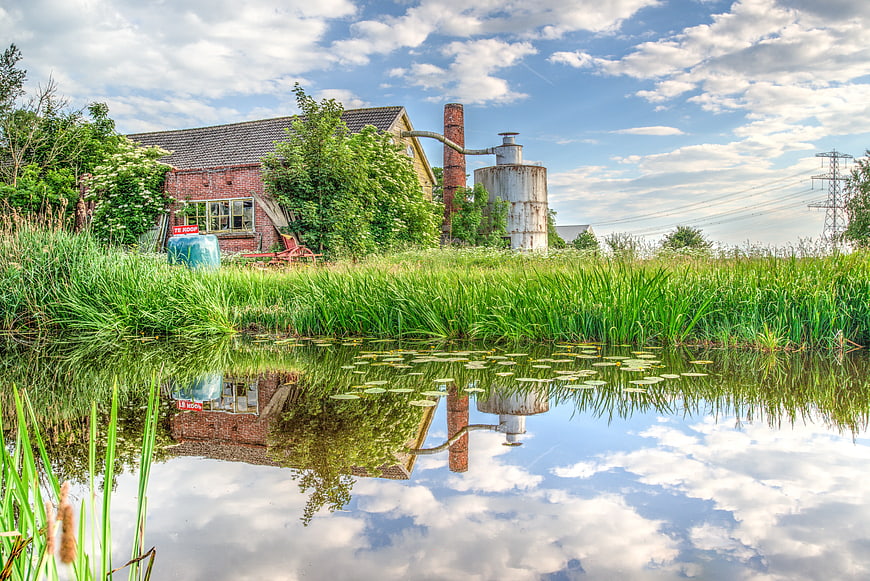 Rustic Farmhouse with Silo Reflected in Pond