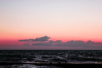 Dramatic Pink Sunset Over Dark Ocean Waves