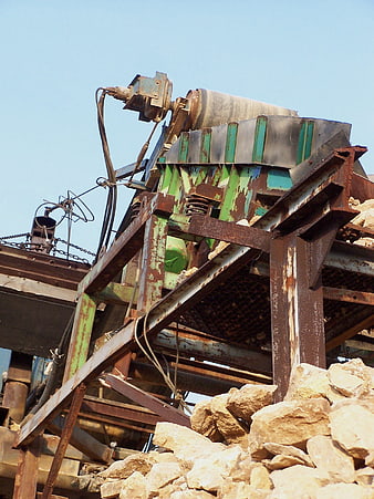 Rusty industrial rock crushing machine with stones