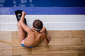 High Angle View of Boy Putting on Flippers by Pool