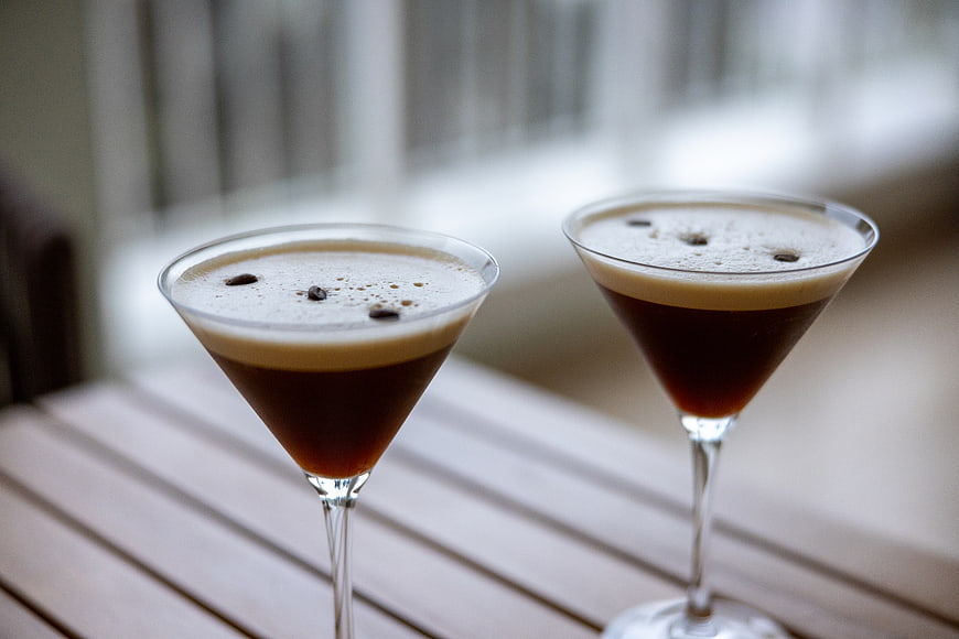 Two Espresso Martinis in Martini Glasses on Wooden Table
