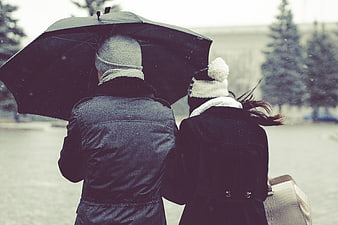 Couple Walking Under Umbrella in Winter Snow