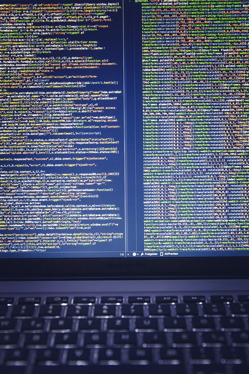 Computer screen displaying lines of code with blurred keyboard