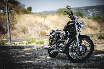 Black Custom Harley Davidson Sportster Motorcycle Parked On Gravel