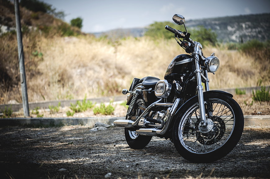 Black Custom Harley Davidson Sportster Motorcycle Parked On Gravel