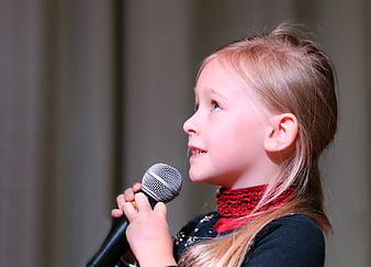 Young Girl Singing into Microphone in Profile