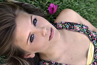 Young woman lying on grass looking at camera