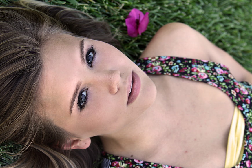 Young woman lying on grass looking at camera