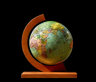 Vintage Globe on Wooden Stand Against Black Background