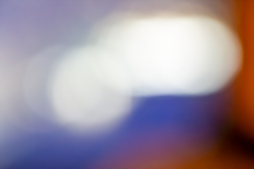 Abstract blurred bokeh lights background with blue and orange tones