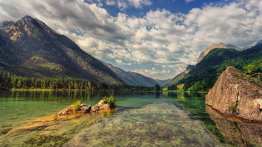 Crystal Clear Alpine Lake with Mountains and Clouds